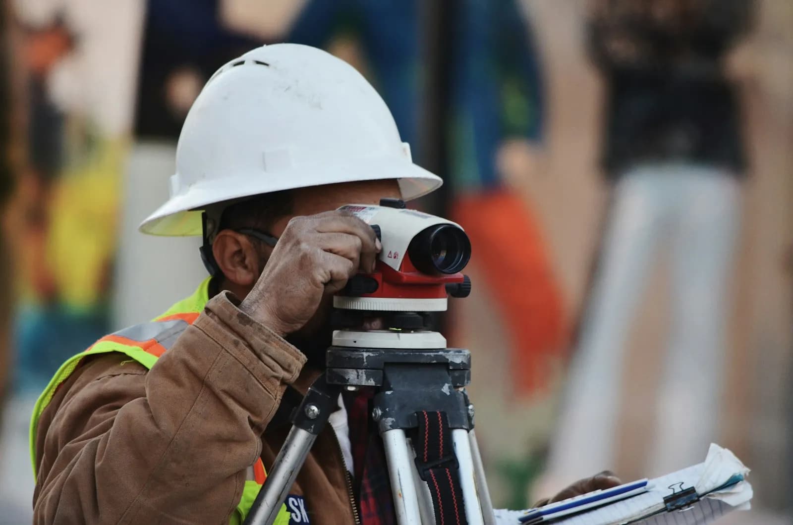 Profissional realizando levantamento técnico com nível topográfico